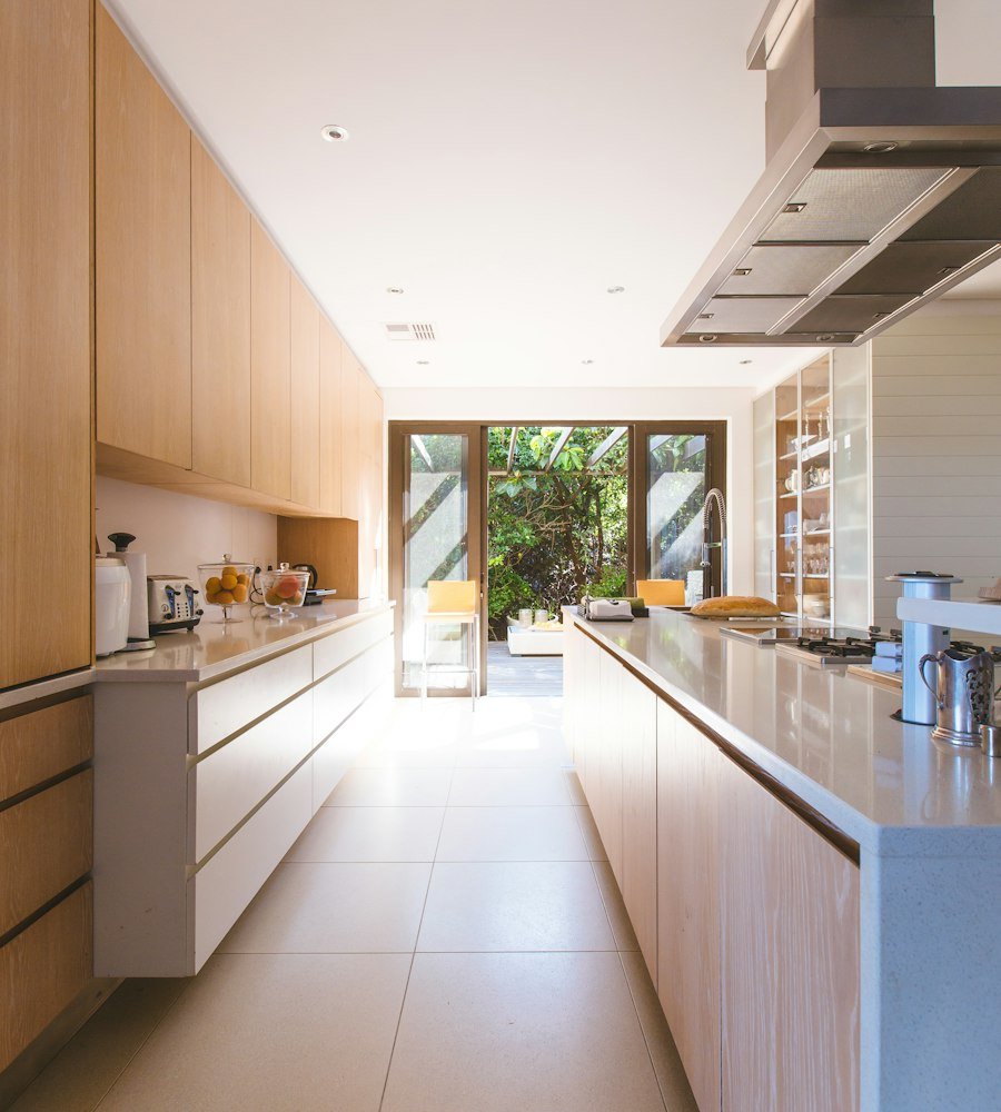 White wooden kitchen island and cupboard cabinets near glass panel door